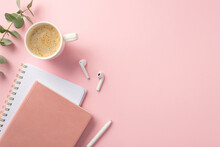 Business Concept. Top View Photo Of Workplace Pink Planners Pen Wireless Earbuds Cup Of Coffee And Eucalyptus On Isolated Pink Background With Copyspace