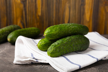 Fresh cucumbers on a white black texture background. Vegetarian organic vegetables.Ingredient for salad. Healthy food.Copy space.Place for text