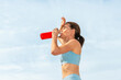 Sporty woman feeling the effects of the sun and taking a drink of water.