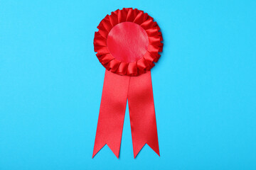 red award ribbon on turquoise background, top view