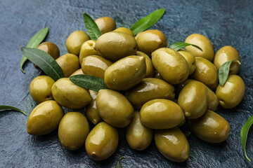 Heap of tasty green olives on dark background, closeup