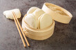 Chinese food Gua bao buns in bamboo steamer closeup on the table. Horizontal