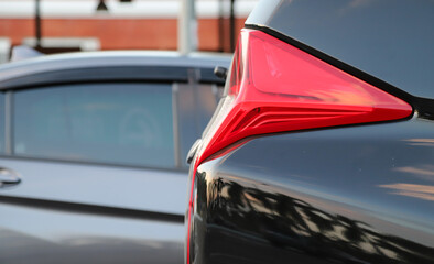 Wall Mural - Closeup of rear, back car-light of black car parking in outdoor parking area.