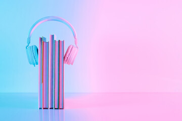 Creative layout made of school books and headphones in vibrant gradient holographic neon colors with copy space. Minimal back to school concept.
