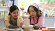 © Prathankarnpap - Pretty asian woman and mature woman enjoying creative process of pottery coloring in pottery workshop