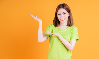 Wall Mural - Photo of young Asian girl posing on background