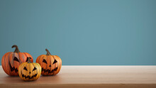 Halloween Carved Pumpkins On Wooden Table Isolated On Blue Colored Background. Halloween Backdrop With Copy Space For Text. Autumn Decoration