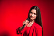 © Alex Vog - Portrait teen girl in stylish red costume over red background with microphone looking at camera