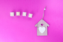 Numbers 2023 On A Pink Background And With A Wooden House. The Concept Of A Home, The Whole Family Is Together