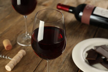 Glasses Of Tasty Red Wine And Chocolate On Wooden Table, Closeup