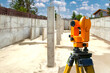 Geodetic device. Optical geodetic equipment. Orange theodolite for surveyor. Construction equipment inside foundation. Surveyor's instrument on tripod. Art focus. Modern geodetic equipment
