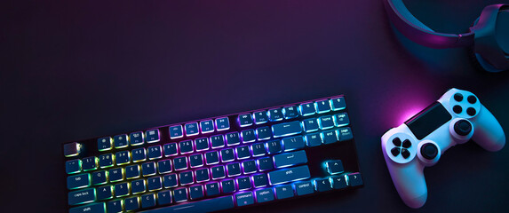 top down view of colorful illuminated gaming accessories laying on table. professional computer game