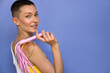 Young woman with whip from sex shop looking playfully to the camera