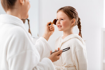 Sticker - beauty, family and people concept - happy smiling mother and little daughter with brush and powder applying make up in bathroom