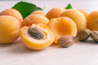 Apricots and kernel on white wooden background. Apricot seeds.
