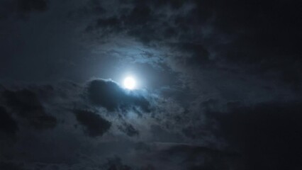 Wall Mural - full moon at night with moving clouds. night timelapse with clouds and stars floating by