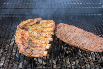 There is nothing more American than grilled beef steaks and pork ribs on a barbecue hot grill.