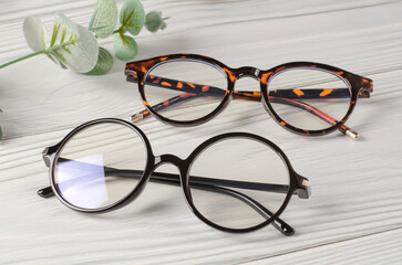 Sticker - Stylish female glasses on white wooden table