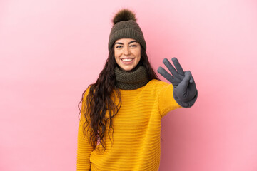 Young caucasian girl with winter hat isolated on purple background happy and counting three with fingers