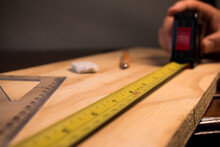 Carpenter Taking Wooden Table Measurements With Some Tools 