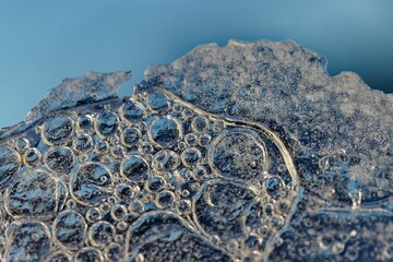 Poster - Macro shot of foam bubbles on a blue background. Abstract colorful background with light