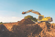 Excavator machine working and digging ground on blurred background