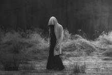 A Mysterious Figure In The Marshes, A Phantom, Fear, Dark Mood. Horror Character, Horror Atmosphere. A Character Resembling Death In The Middle Of A Flooded Meadow.
