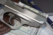 Small Pistol And Money In Office Environment