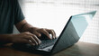 © THAWEERAT - Freelance businessman working from home. Close up of hand with a laptop computer.