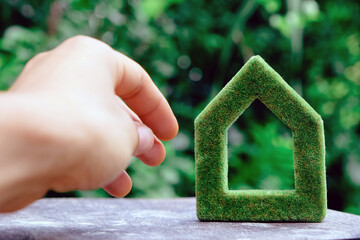 Fototapete - hand holding eco house icon in nature