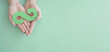 Hands holding green infinity arrow symbol, circular economy, sustainable and responsible business growth concept