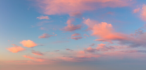 Wall Mural - pastel light pink clouds in the blue sky during dawn sunset, sky background