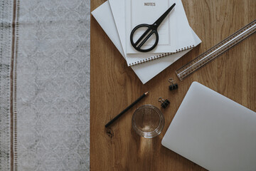 Wall Mural - Laptop computer, glass of water, stationery on wooden table background. Flat lay, top view aesthetic minimal freelancer, blogger home office desk workspace.
