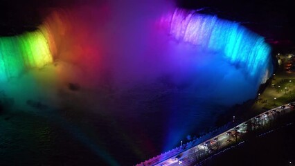 Wall Mural - Aerial view of Horseshoe Falls winter illumination in twilight time. Niagara Falls City downtown horizon. Stunning landscape dusk to night.