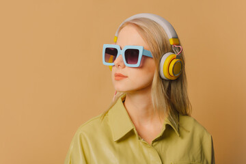 Poster - Stylish 80s woman in eyeglasses and headphones on brown background