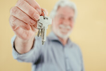 Defocused Senior Agent Man Holding Keys Of New House Apartment Rent Buy Sell