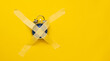 Blue clock sticked up crosswise with masking tape isolated on yellow background with copy space. Concept of timeless things in life, deficiency of time. Weekend morning without work hours