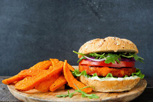 Plant Based Vegan Burger And Sweet Potato Fries. Side View Against A Dark Background.