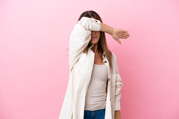 Wall Mural - Middle age caucasian woman isolated on pink background covering eyes by hands