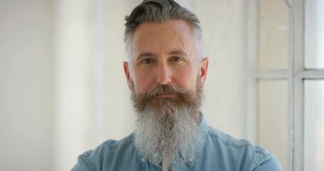 Poster - Closeup portrait of stylish retro male with grey hair and stern expression, with a calm and collected attitude about life. Face portrait of a serious mature man with a full beard standing in a room