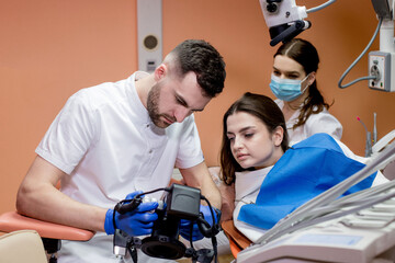 The dentist shows the patient a picture of the result of treatment. Satisfied patient