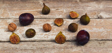 Close-up Vintage Composition Made Of Fresh Ripe Figs, Plums And Nuts On Old Wooden Table. Dark Background. Retro Style Food Concept.