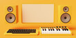 Orange monochromatic home music studio consisting of midi keyboard and desktop computer