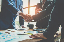 Business Team Shaking Hands And Clapping After A Business Deal Image Of Business Partners Handshaking Over Business Objects In The Office