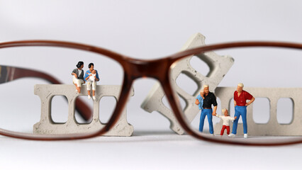 Wall Mural - Business concept with a glasses and a miniature gay couple family. Concept about 'love is love'. 
