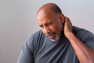 Portrait of an older senior man having pain in his neck.