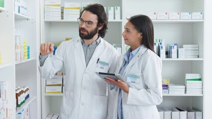 Poster - Pharmacists working together stocktaking medication at the pharmacy. Two healthcare professionals discussing a patient prescription at a dispensary. Two medical doctors talking about medicine tablets
