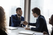 © fizkes - Company leader, boss congratulating happy successful employee on career growth, success, shaking hand with recognition, reward. Business partners giving handshakes, ending meeting, closing deal