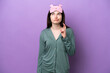 © luismolinero - Young Russian woman in pajamas isolated on purple background with fingers crossing and wishing the best