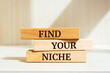 Wooden blocks with words 'FIND YOUR NICHE'.